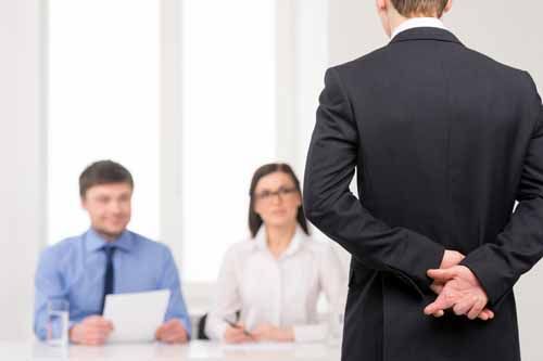 An employees crosses his fingers behind his back while being questioned